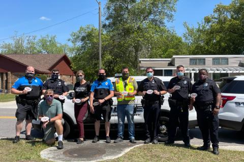 Casselberry Mayor David Henson (kneeling, front) with members of the Casselberry Police Department and Seminole County Sheriff’s Office at Winter Park and Quintuplet drives. 