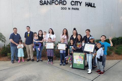 The Arbor Day Poster Contest winners with their families outside of Sanford City Hall on Monday.