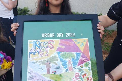 First place winner Lily Lakatani (above) holds a framed poster featuring her winning artwork. 