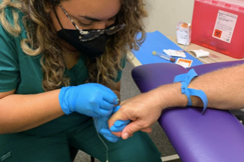 An Audere Institute student practices her skills to learn to become a phlebotomy technician.