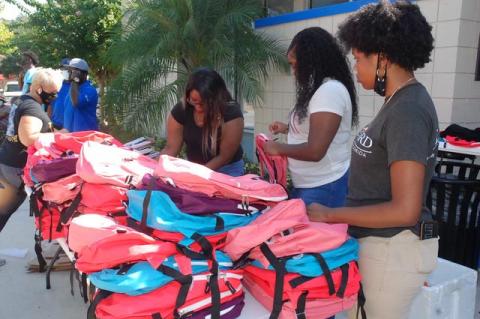 Volunteers help to fill the backpacks and check parents in who had registered to pick up them up. Backpacks were given to elementary, middle and high schoolers. 
