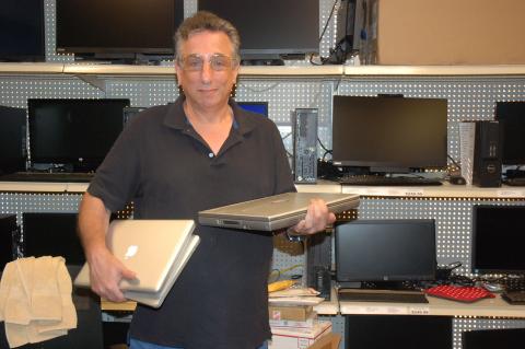 Glen Coffield of Smart Guys Computers holding some of the laptops that have already been donated.