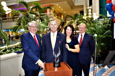  Colonel David A. Smith receives the Colonel Joe Kittinger Award from GOAA CEO Kevin Thibault, Board Treasurer Belinda Kirkegard and Board Chairman Carson Good prior to the Orlando Philharmonic Orchestra performing a collection of patriotic tunes in front of travelers from around the world. 