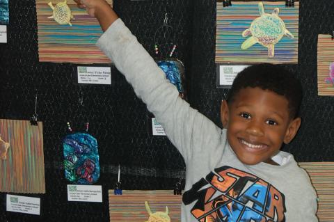 Crystal Lake Kindergartener Gabriel Brown points to his artwork at the art festival.