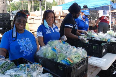 Members of the Chi Phi Zeta soroity hand out vegetables Friday during in Goldsboro. 