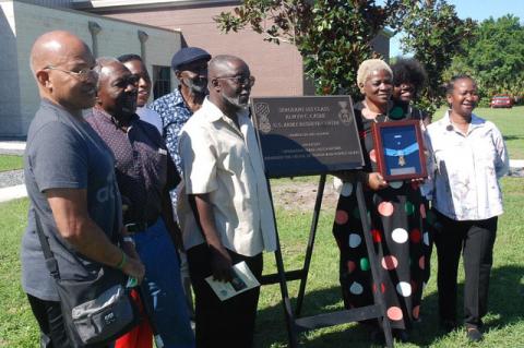 Members of the Cashe family pose around the dedication plaque for Sgt. 1st Class Alwyn Cashe on Friday morning.