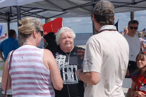Mary Ingrassia, (above) known as Navy Mom Mary, center, talks with people as she handed out about 100 folded flag pins that she makes in honor of those “who paid the ultimate price." 