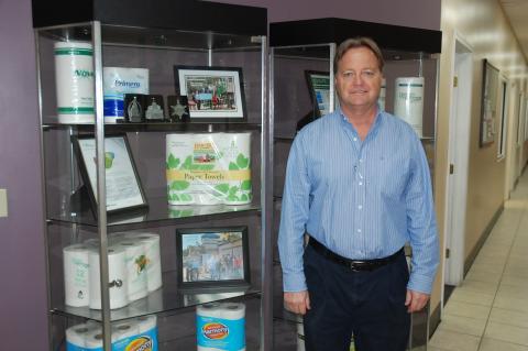 General Manager Bob Visscher stands next to a display case holding tissue products produced at Resolute Tissue in Sanford.