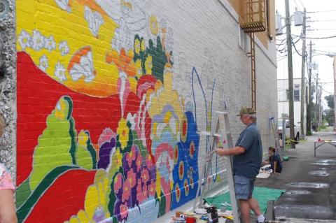Steward Jones (above) outlines a part of the Hotchkiss Building’s 63-foot mural. 