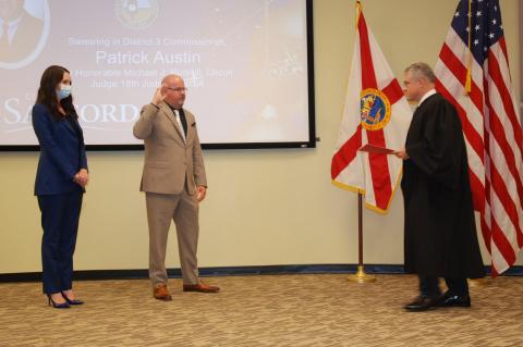 Commissioner Patrick Austin (center) was sworn-in for his second term as commissioner for District 2.