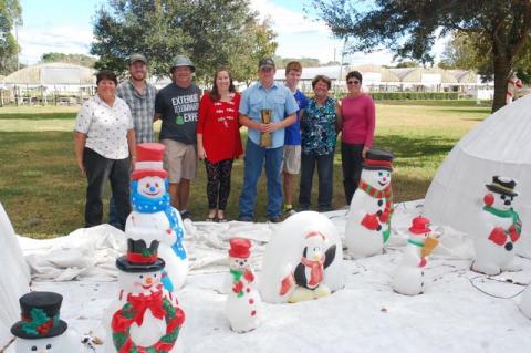 The Lammerse family poses with just a portion of the snowmen that are part of their annual display that has run since the 1960s. From left, Annette, Steven, John, Kristi, Travis (holding the 1966 trophy), Connor, Jinny and Frances.