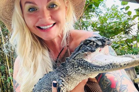 Gatorland Crocodilian Enrichment Coordinator Savannah Bloan holds the gator rescued from Seminole County.