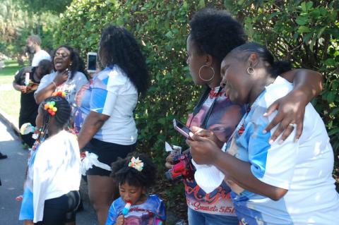 Family and friends of Adrein Green grieve while Ashley Williams, woman at far left, sings.