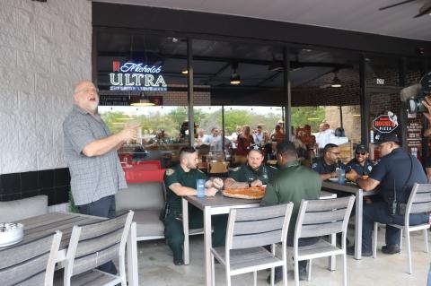 The Seminole County Sheriff’s Office and Lake Mary Police Department get ready for the pizza-eating content (above) as part of the fundraising event held Tuesday at Bronx House Pizza. 