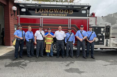 Jacob Gorgans (center) stands with the firefighters of Longwood Station 15. Eight years ago the members of the station helped Jacob’s parents when he suffered from a seizure as a child.