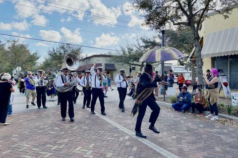 Kid Dutch and Perseverance Brass Band (above) march down Sanford Avenue on Saturday afternoon for the annual Mardi Gras sashay.