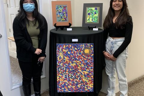8th grader Domenica Barros (left) and 7th grader Mariaisabel Torres stand with their artwork on Thursday evening. 