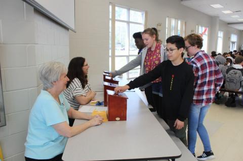 Students at Markham Woods Middle School donate money to the cause of Jeni Meriwether, an eighth grade teacher battling breast cancer, on Monday afternoon.