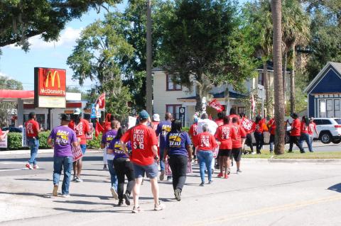 Protestors walk out front of the McDonald’s on Tuesday in Sanford. 