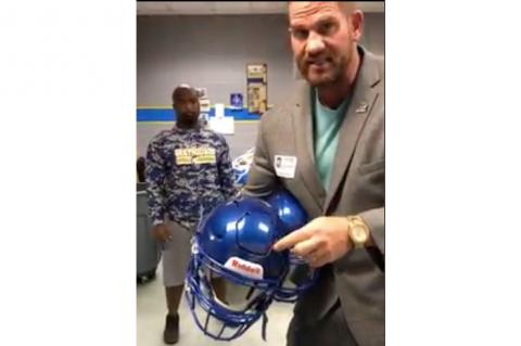 Matt Morgan shows the football helmets he hopes to raise money for. 