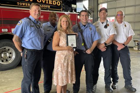 Local school teacher Suzanne Matos (center) was recently presented the Life-Saving Award from the City of Oviedo for helping two children escape from a burning vehicle.