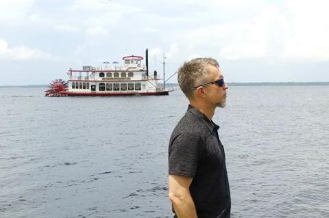Raw Travel Host Robert G. Rose (above) on the shoreline of Lake Monroe with the Barbara Lee in the background. 