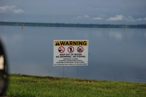 Warning signs are posted along Lake Monroe until officials can determine it is safe to swim and fish. 