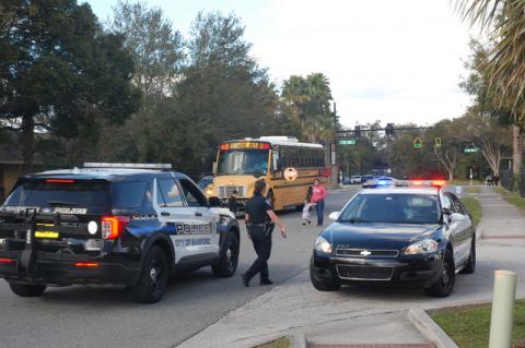 A school bus drops off children on Ridgewood Avenue among the police presence on the road while a shooting investigation took place at Seminole High School on Wednesday.