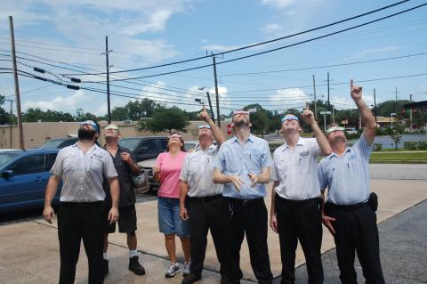 Owners and employees at Harrell & Beverly Transmissions & Auto Repair look up back in 2017 during a solar eclipse. Everyone was sure to wear specially made glasses for the event. 