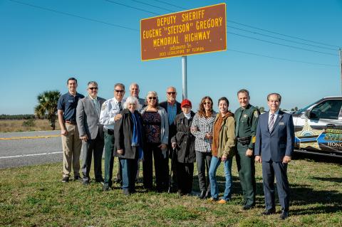Deputy Eugene ‘Stetson’ Gregory’s family stand with Sheriff Dennis Lemma and State Senator Tom Wright (right) under the newly revealed sign designating a portion of S.R. 46 as Deputy Sheriff Eugene ‘Stetson’ Gregory Memorial Highway. The portion of dedicated road runs from Kings Landing to Jolly Gators in Geneva.