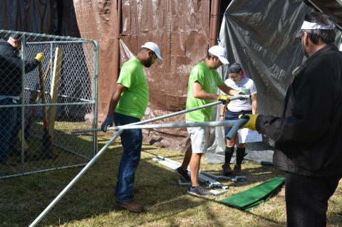 Volunteers with Florida Power & Light Company work to build one of the animal habitats that will be used for the Zoo’s animal ambassador program.